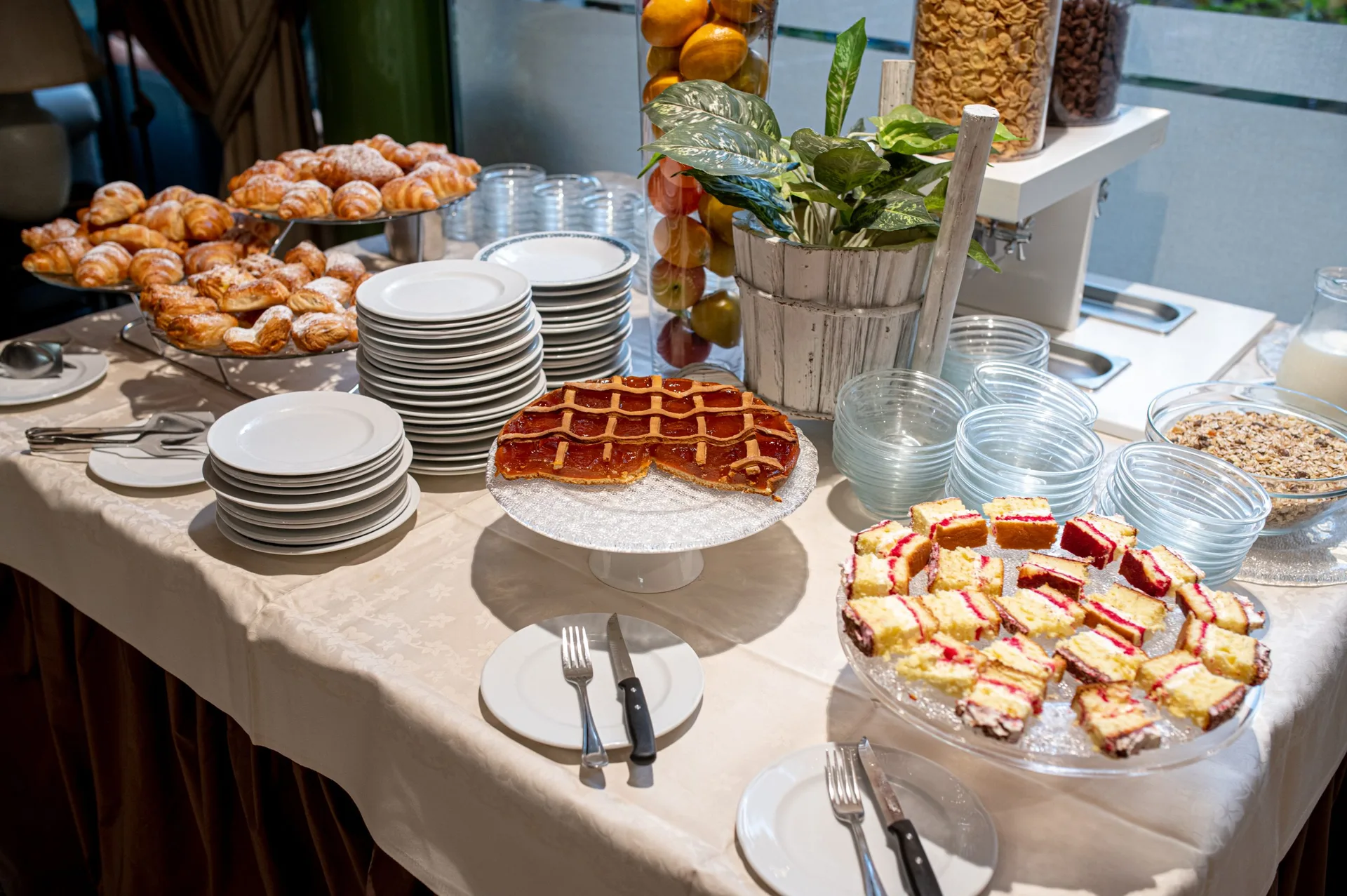 Buffet della colazione con cornetti, crostata, dolci e cereali