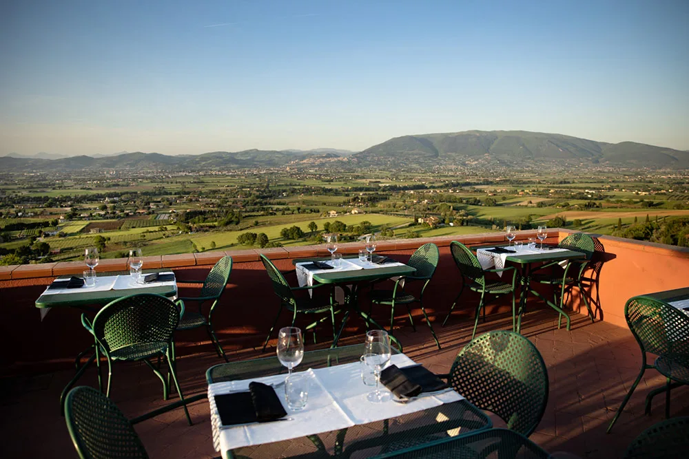 Terrazza panoramica con tavoli apparecchiati e vista sulla valle umbra