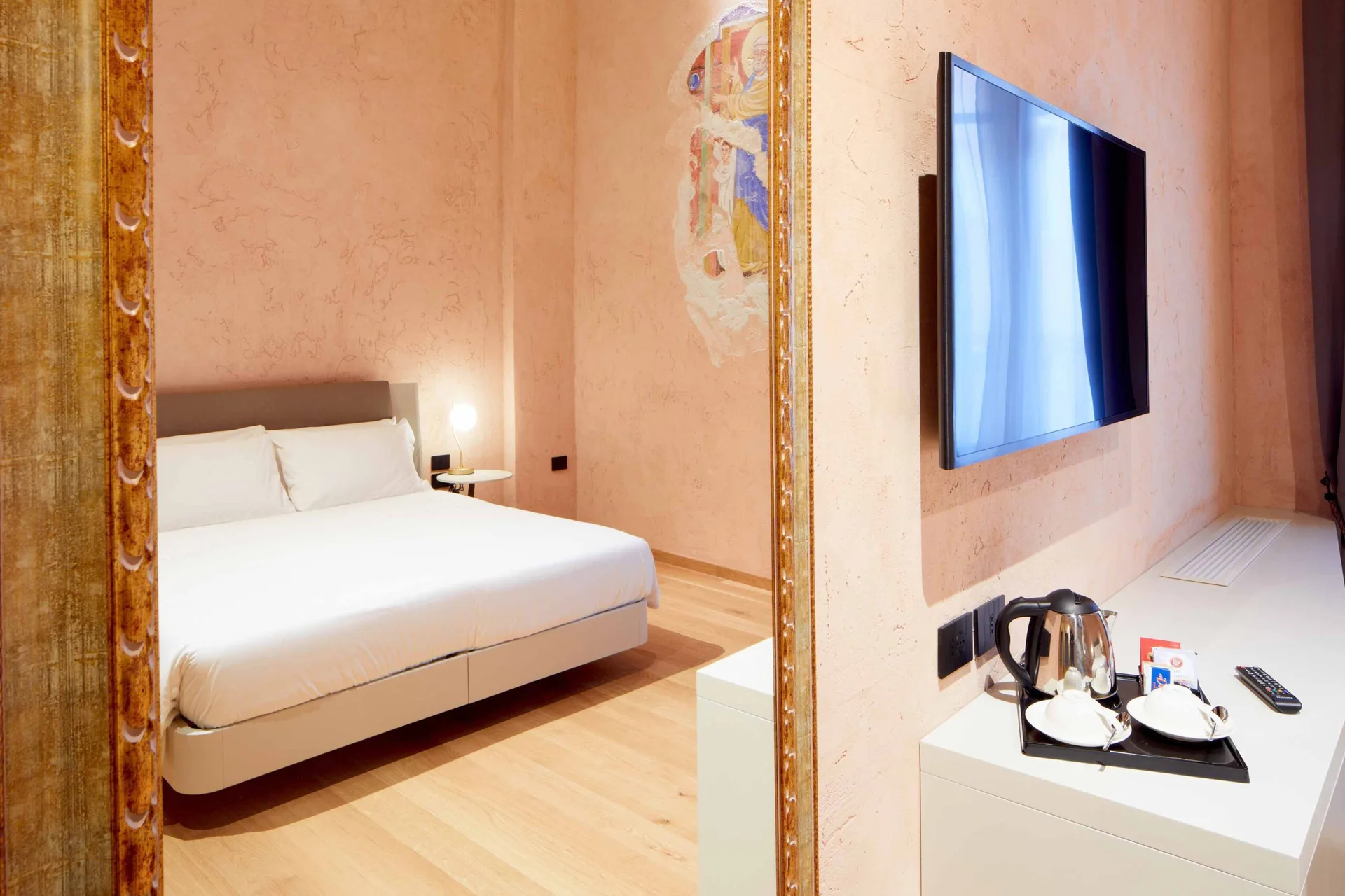 Camera con letto matrimoniale, affresco sacro e TV a parete