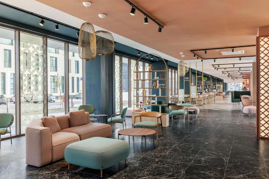 Spaziosa hall lounge con divani, poltrone e grandi vetrate