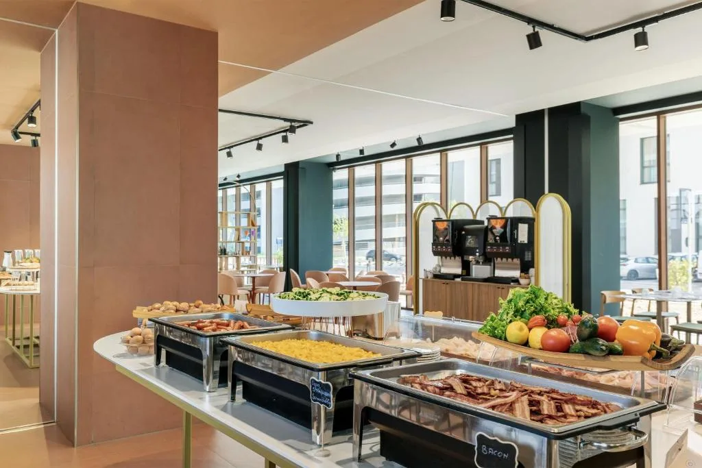 Buffet caldo con bacon, uova e verdure fresche