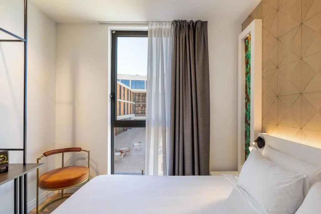Camera con letto, poltrona e finestra affacciata sulla terrazza