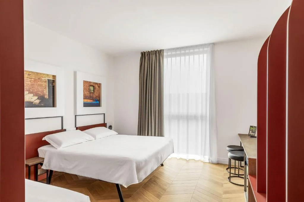 Camera luminosa con letto matrimoniale, scrivania e ampia finestra