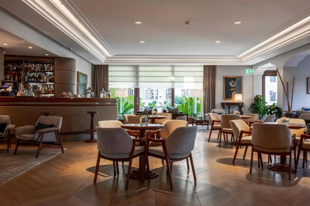 Hall con bar, tavoli e poltrone in stile elegante e pavimento in legno