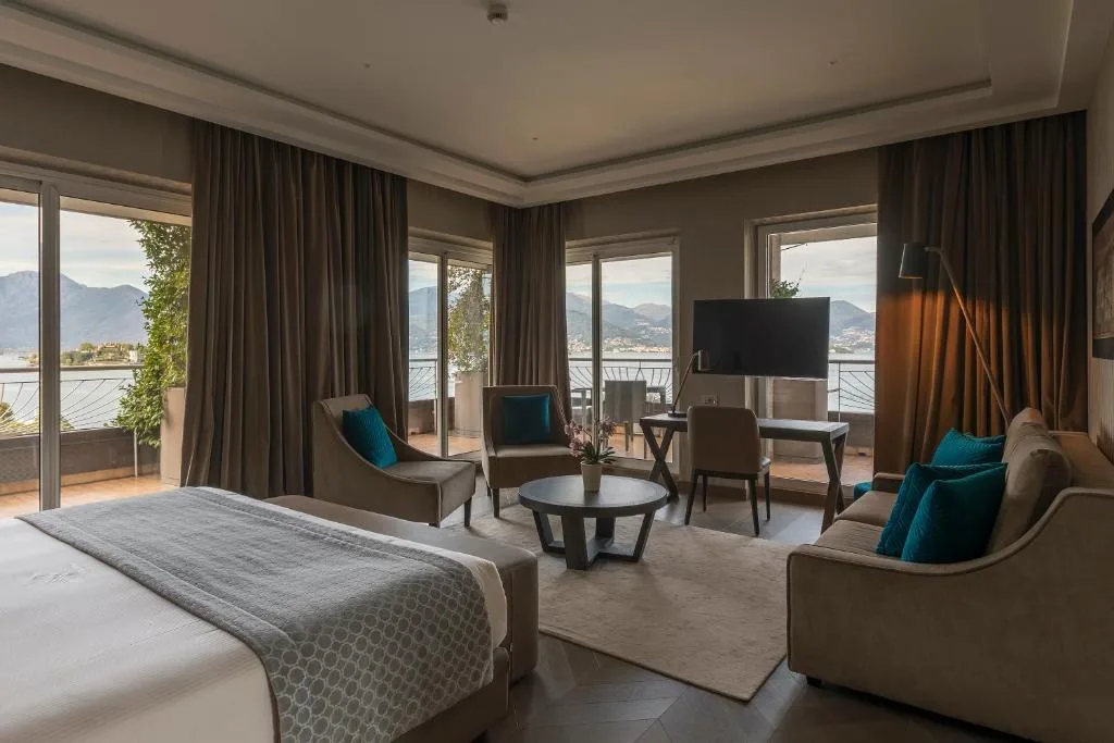 Suite spaziosa con letto, zona soggiorno e ampie vetrate con vista sul lago