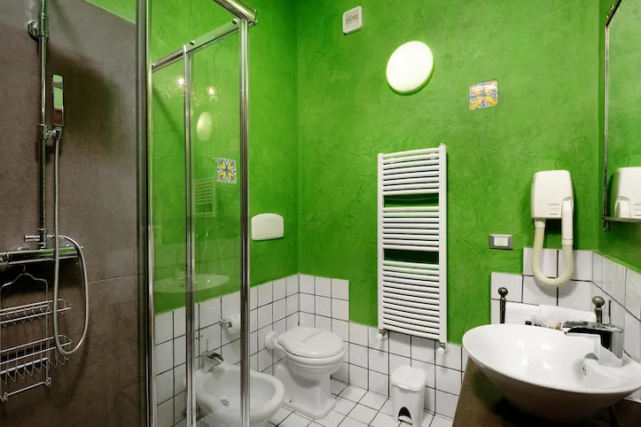 Bagno moderno verde con doccia, sanitari e termoarredo bianco