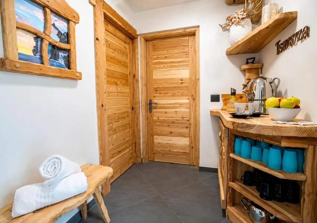 Angolo tisaneria della spa con mobili in legno rustico, ciotola di frutta e asciugamani