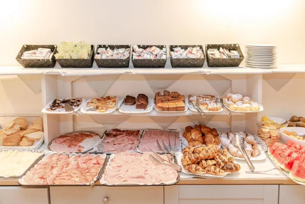 Dettaglio del buffet con affettati, cornetti al cioccolato e frutta di stagione