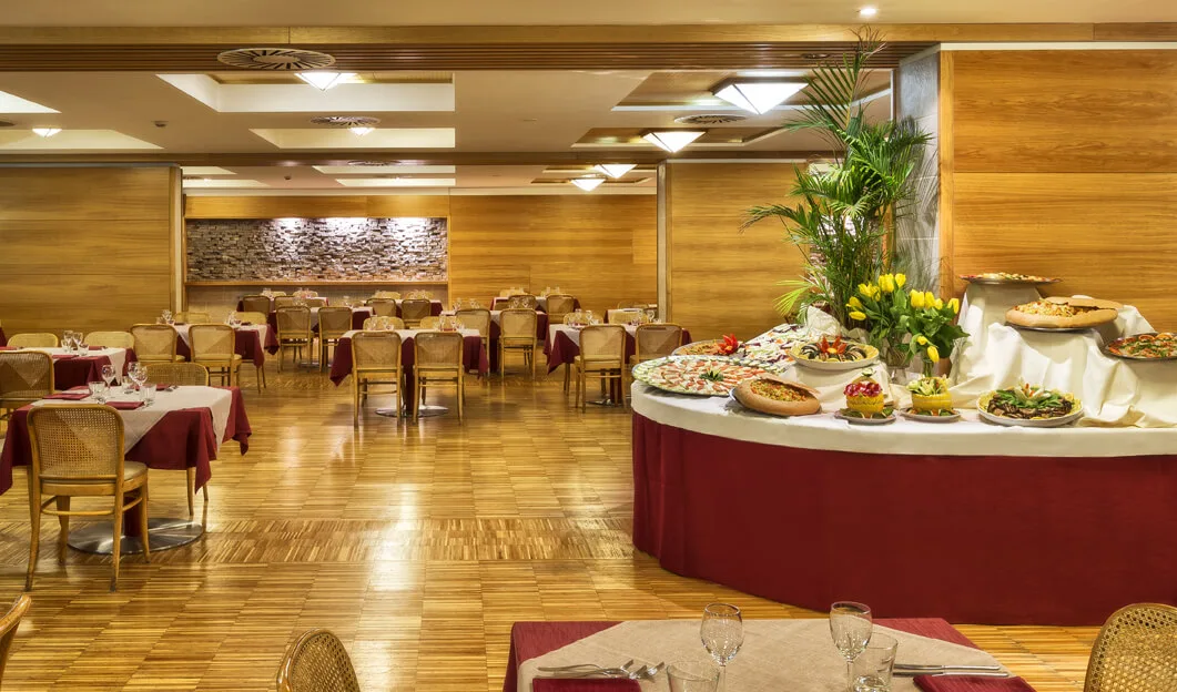 Sala ristorante con pareti in legno, tavoli apparecchiati e buffet ricco di piatti