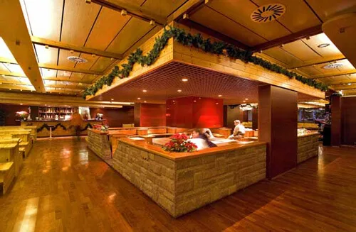 Area lounge con bancone in legno, decorazioni natalizie e sedute panoramiche