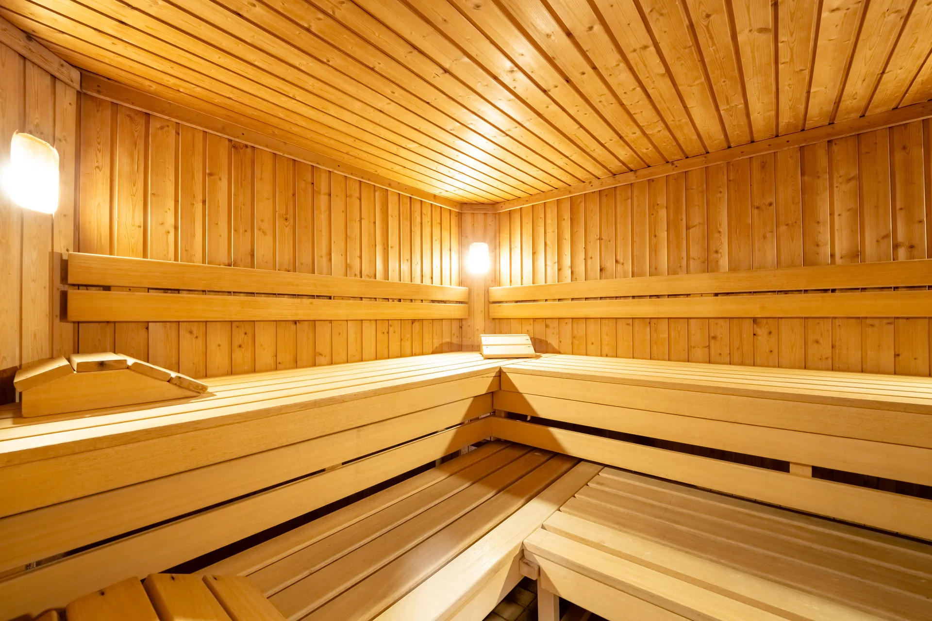 Sauna finlandese in legno con panche e illuminazione soffusa