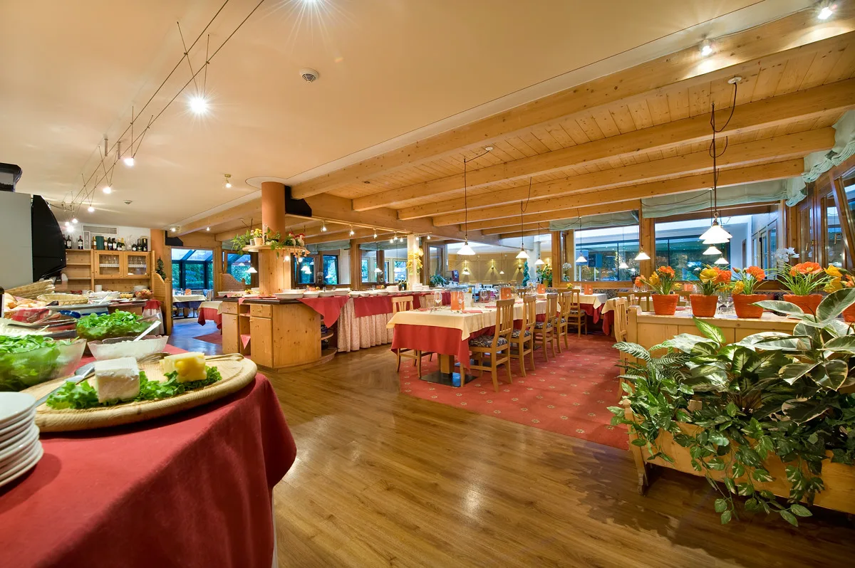 Ampia sala ristorante con buffet, soffitto in legno e decorazioni floreali