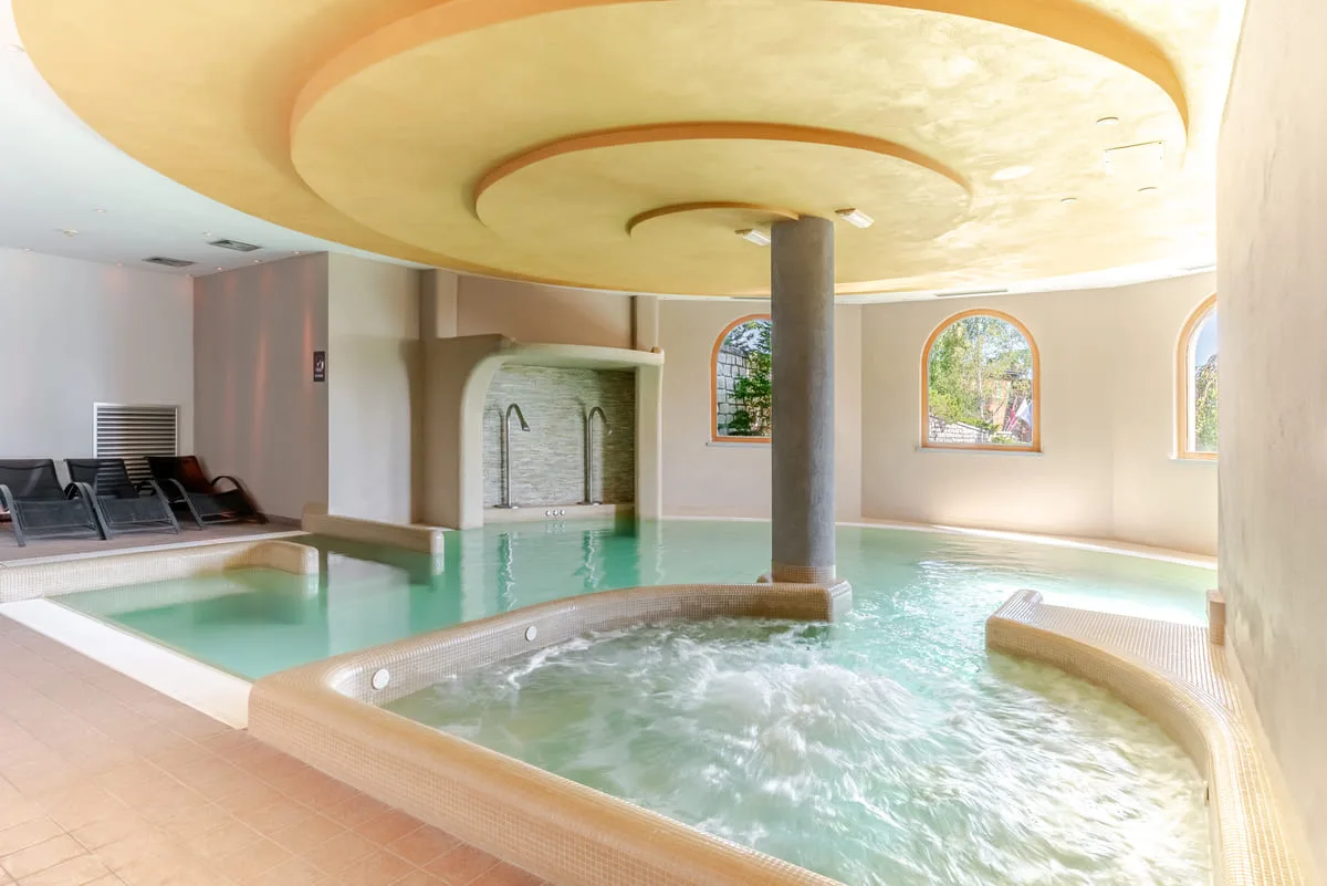 Piscina interna con idromassaggio e vetrate ad arco