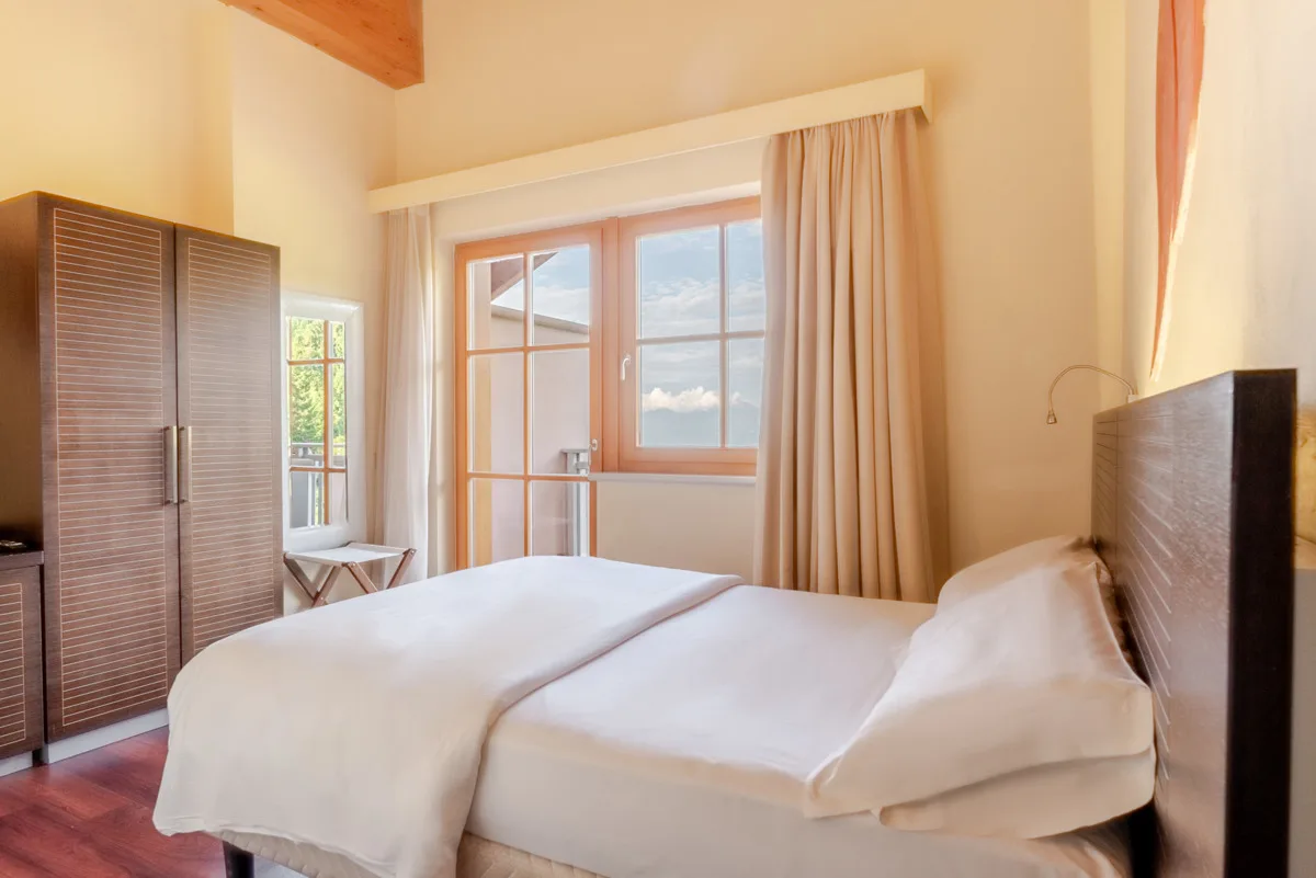 Camera matrimoniale luminosa con letto e vista sulle montagne