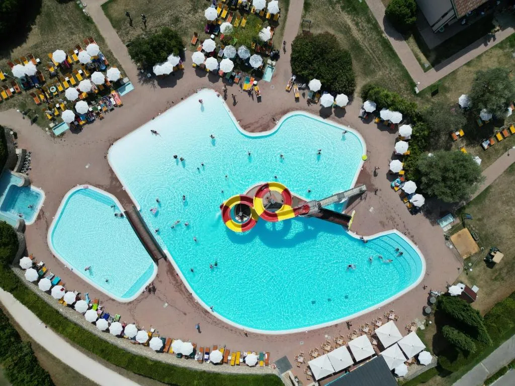 Veduta aerea del parco acquatico con piscine, scivolo e ombrelloni