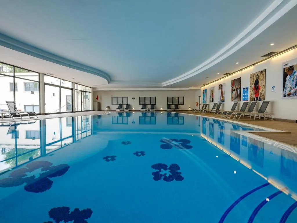 Piscina coperta interna con lettini e decorazioni floreali sul fondo