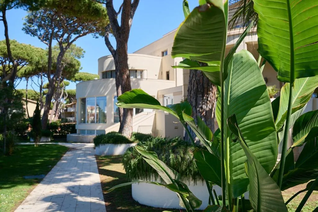 Vialetto nel giardino tropicale con piante rigogliose e edificio dell'hotel