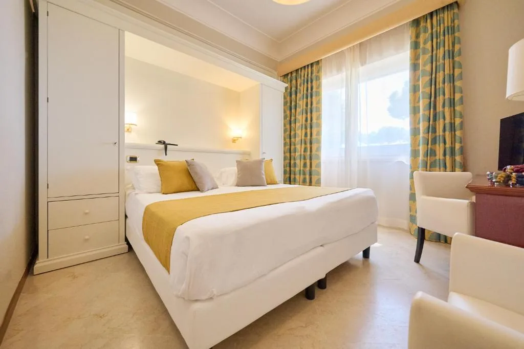 Camera luminosa con letto matrimoniale, armadio bianco e tende decorate