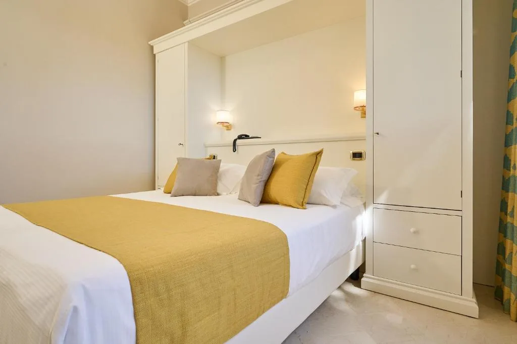 Camera confortevole con letto matrimoniale, armadio bianco e biancheria gialla
