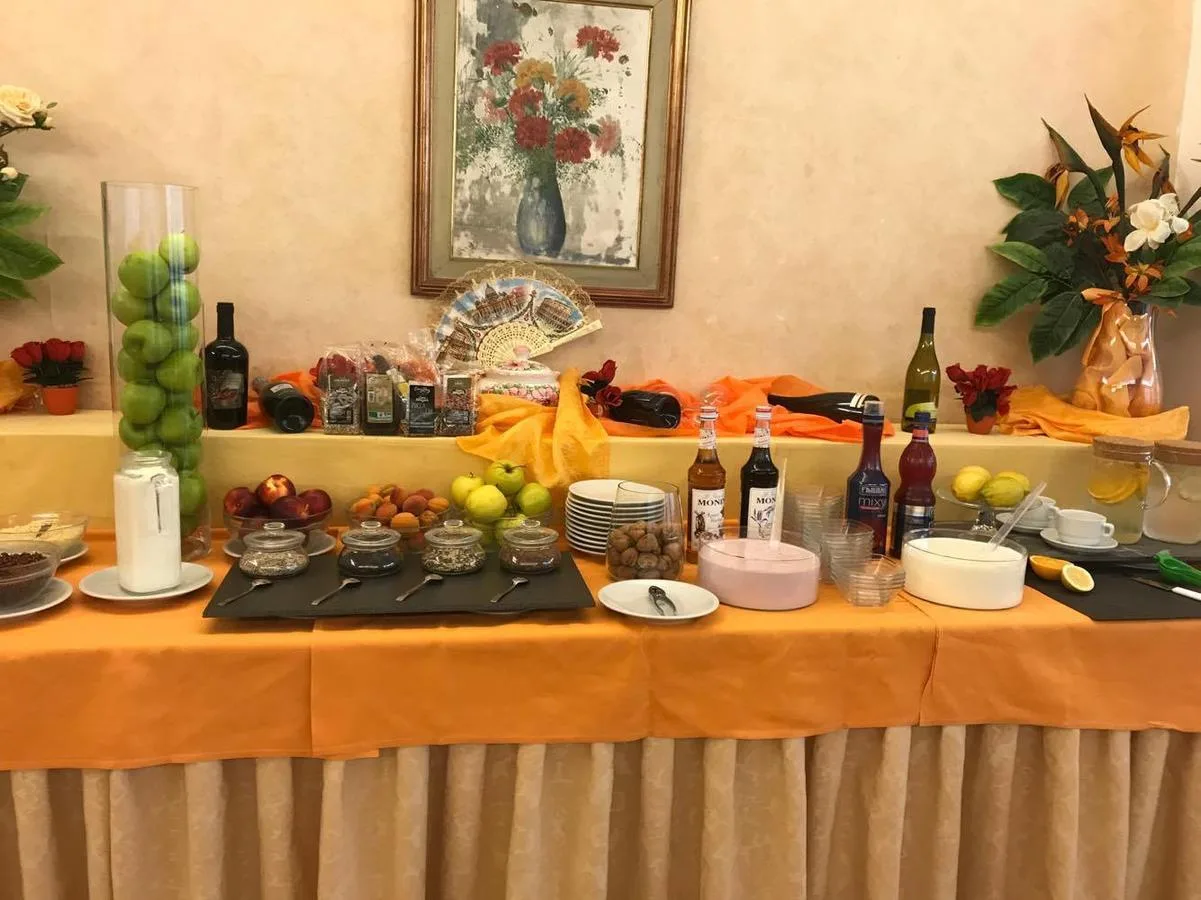 Buffet della colazione con frutta fresca, cereali e composte su tavolo arancione