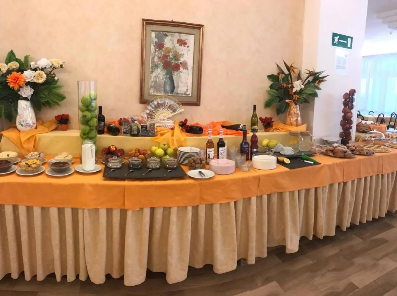 Buffet della colazione con frutta, dolci e decorazioni floreali