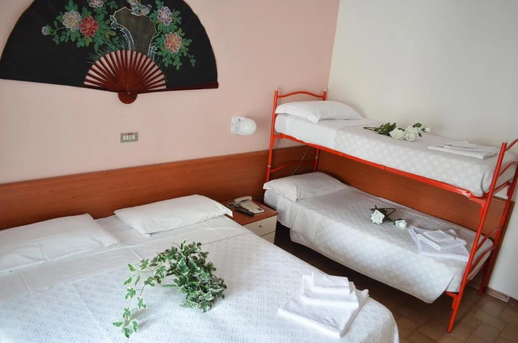 Camera con letto matrimoniale e letto a castello, decorazione a ventaglio sulla parete