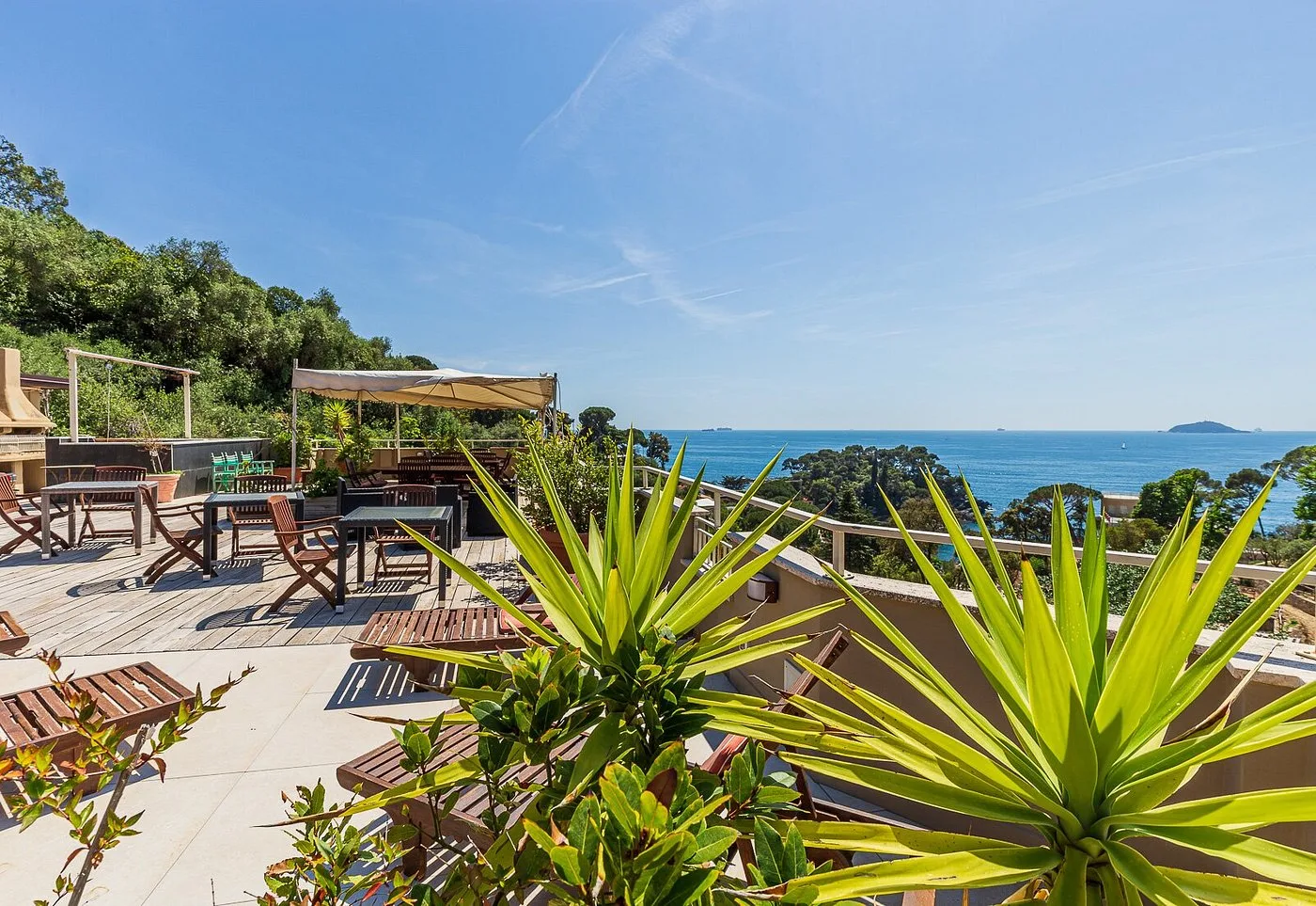 Terrazza panoramica con lettini e gazebo affacciata sul mare e la vegetazione