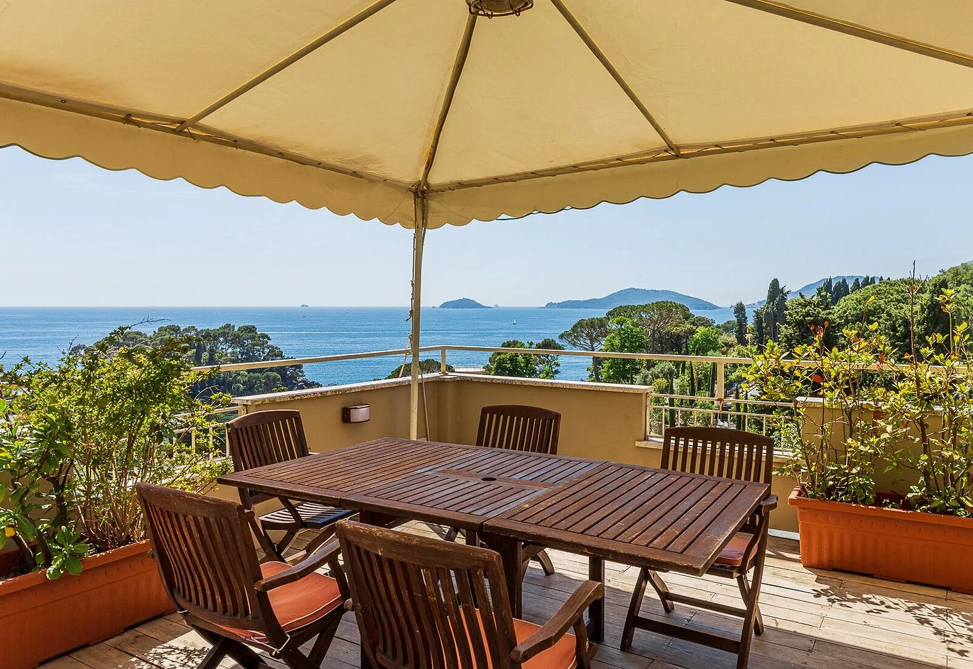 Terrazza con tavolo e sedie sotto un gazebo con vista panoramica sul mare e le isole