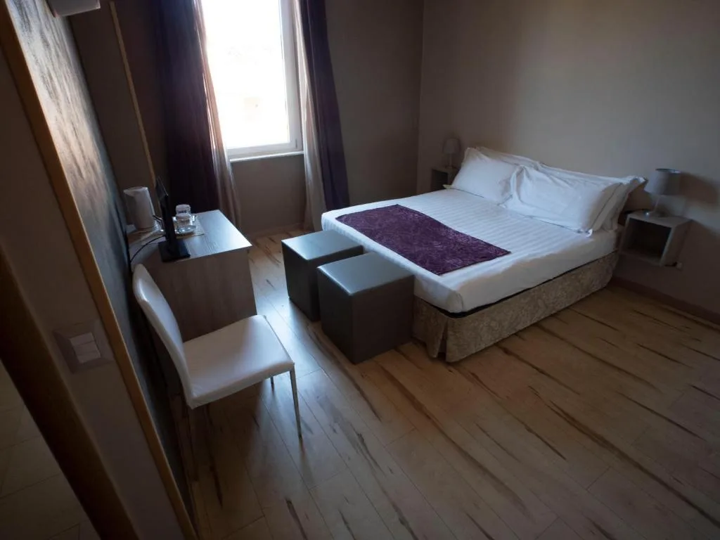 Camera matrimoniale con parquet, scrivania e finestra luminosa