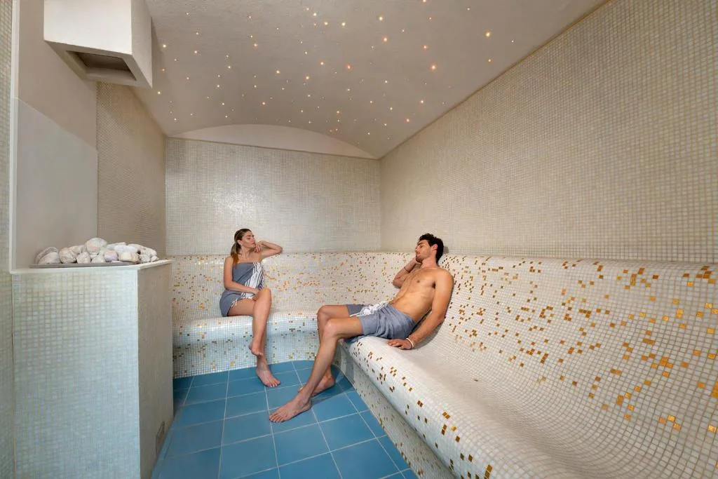 Bagno turco con mosaico dorato e soffitto a cielo stellato con due persone