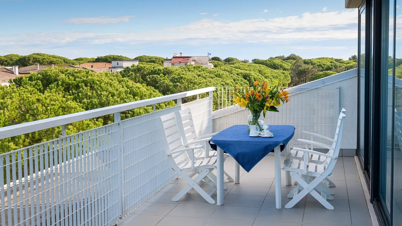 Terrazza con tavolo e sedie affacciata sulla pineta