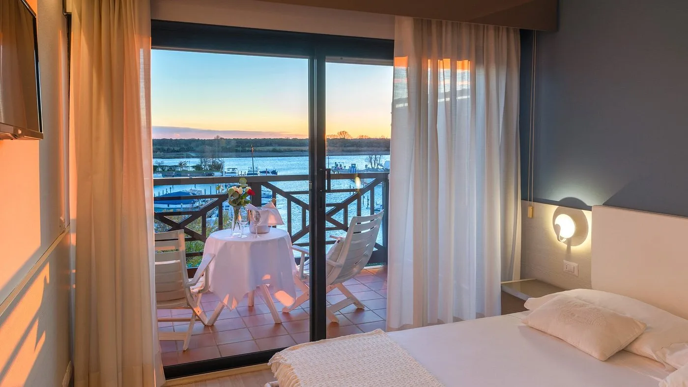 Camera con balcone e vista sul fiume al tramonto