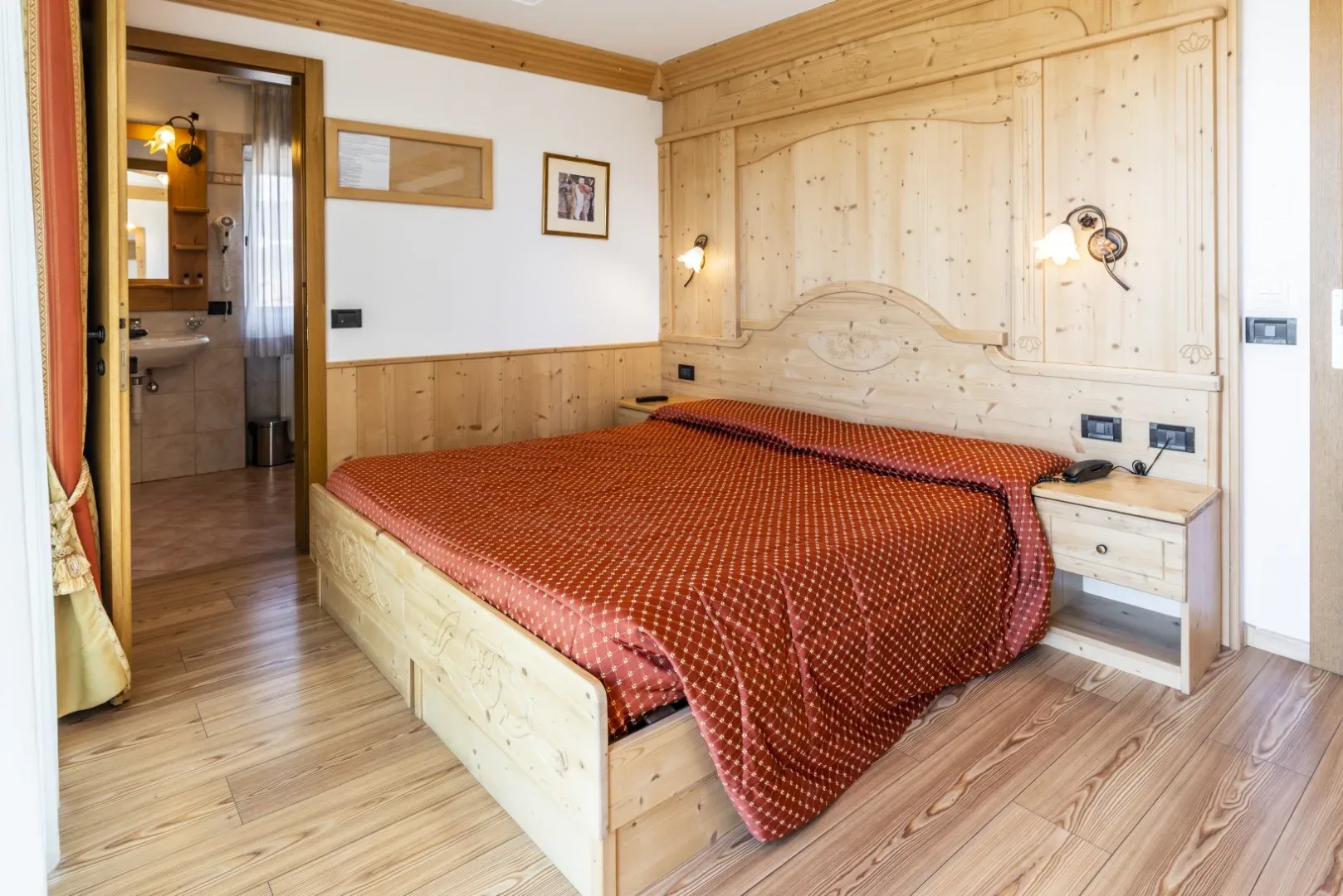 Camera in stile tradizionale con arredi in legno chiaro e bagno privato