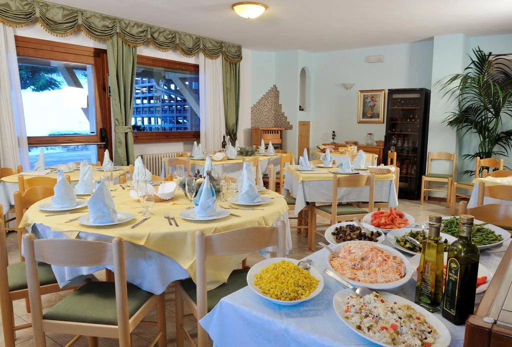 Tavoli del ristorante apparecchiati con buffet di contorni in primo piano