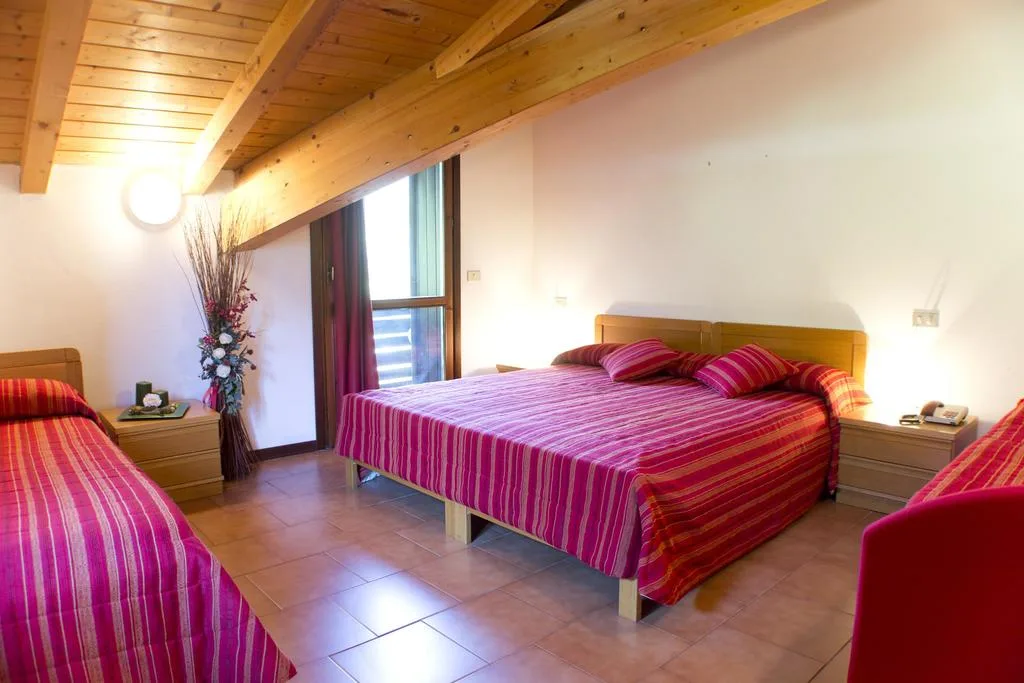 Camera tripla con travi a vista, letto matrimoniale e letto singolo