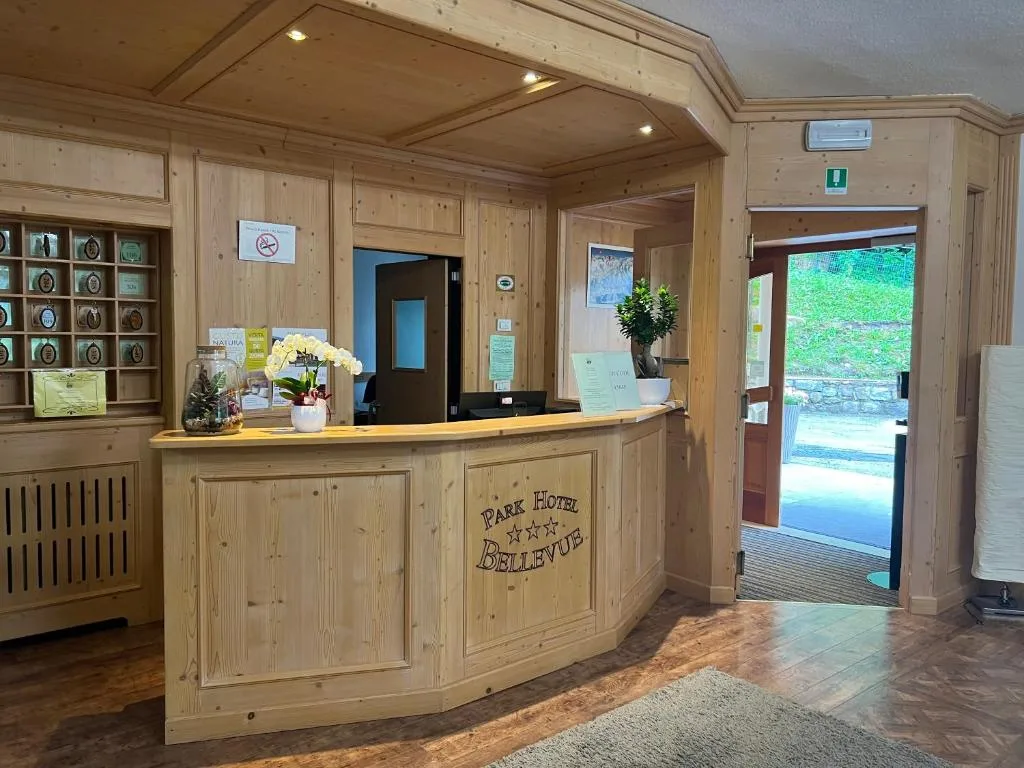 Reception del Park Hotel Bellevue con bancone in legno e orchidea bianca