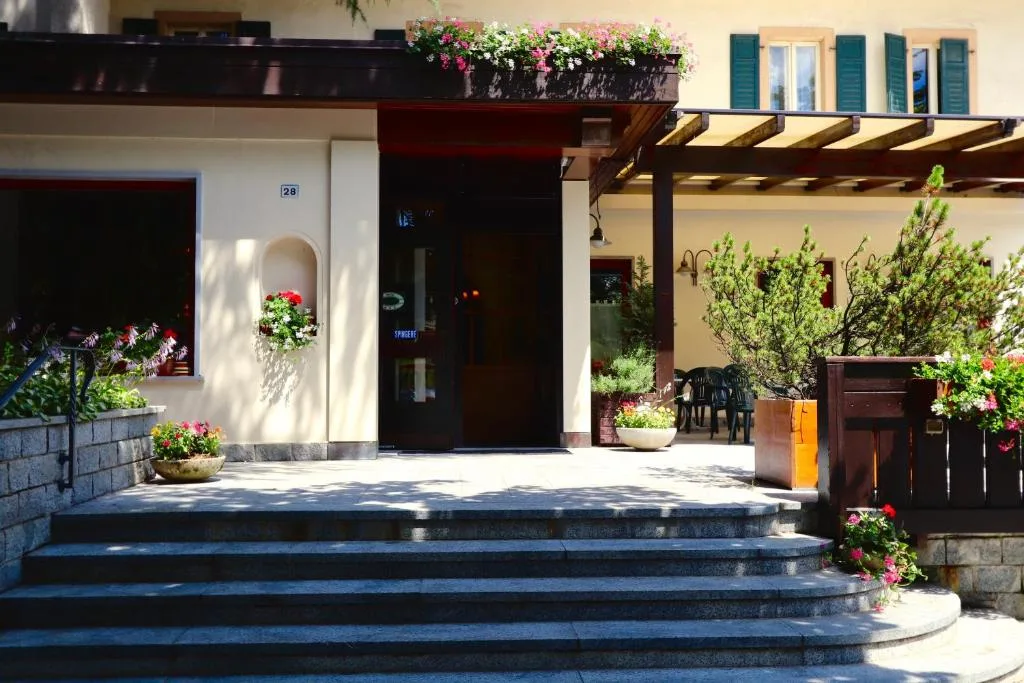 Scalinata d'ingresso dell'hotel con porta d'entrata, fioriere e piante