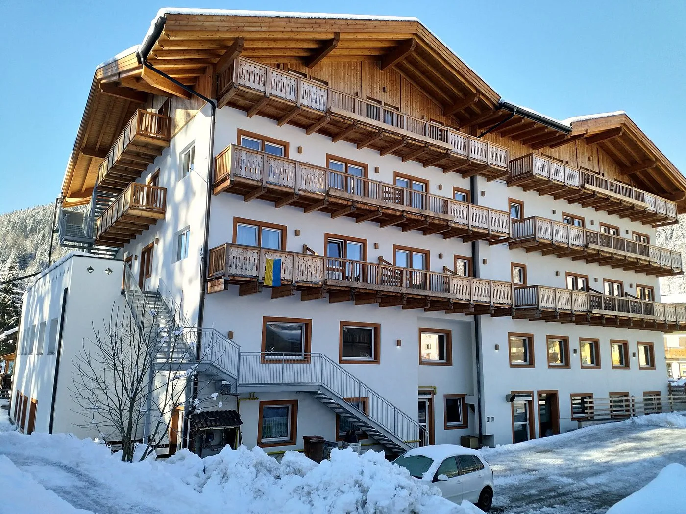Retro dell'hotel con balconi in legno e scale esterne in giornata invernale soleggiata
