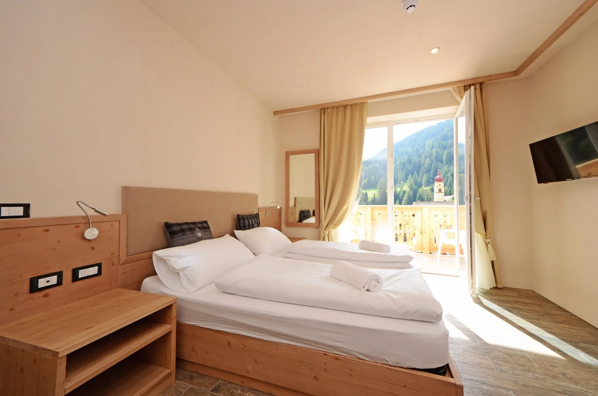 Camera luminosa con letto matrimoniale e balcone con vista sulle montagne
