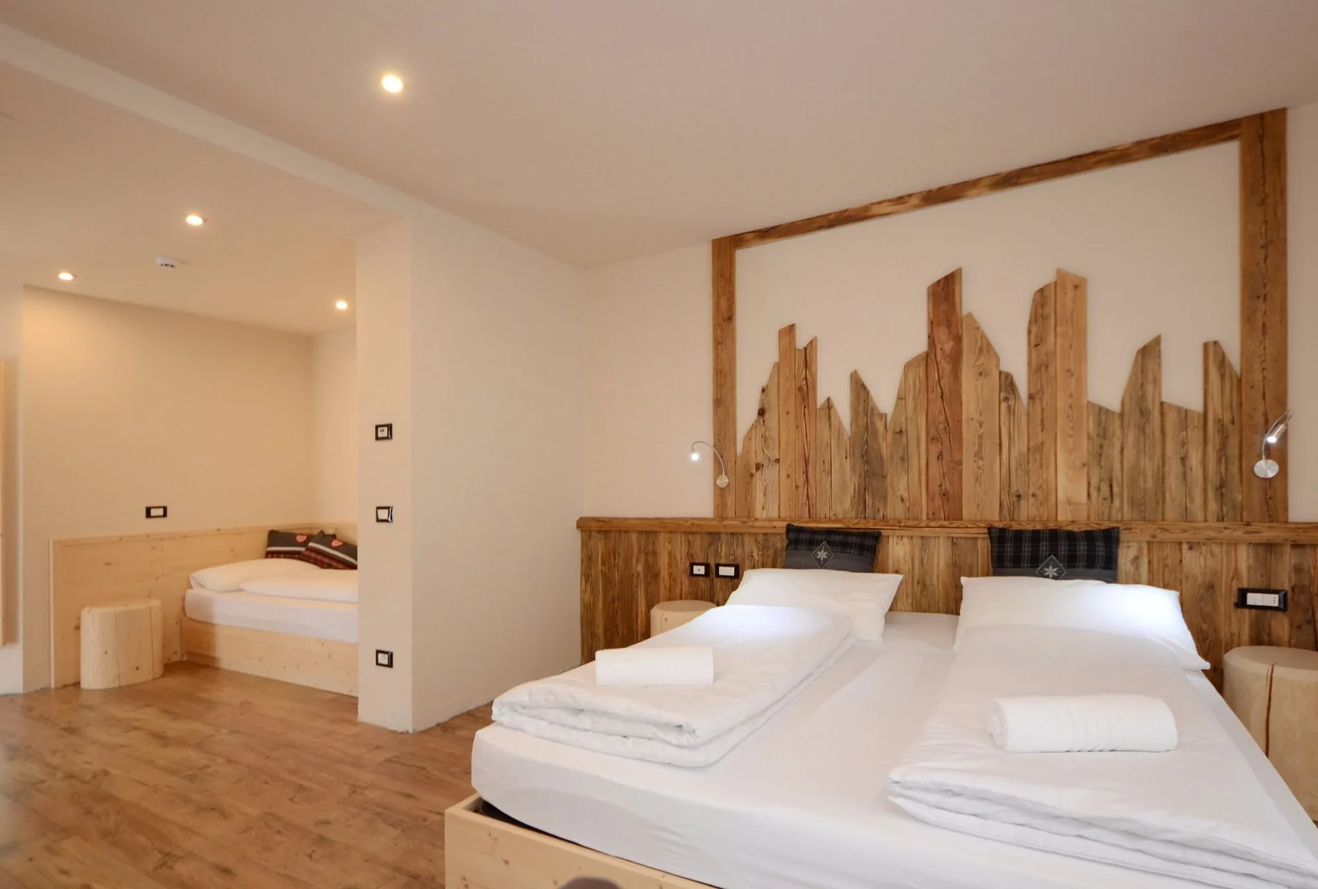 Camera con letto matrimoniale e letto singolo aggiuntivo, arredo in legno chiaro