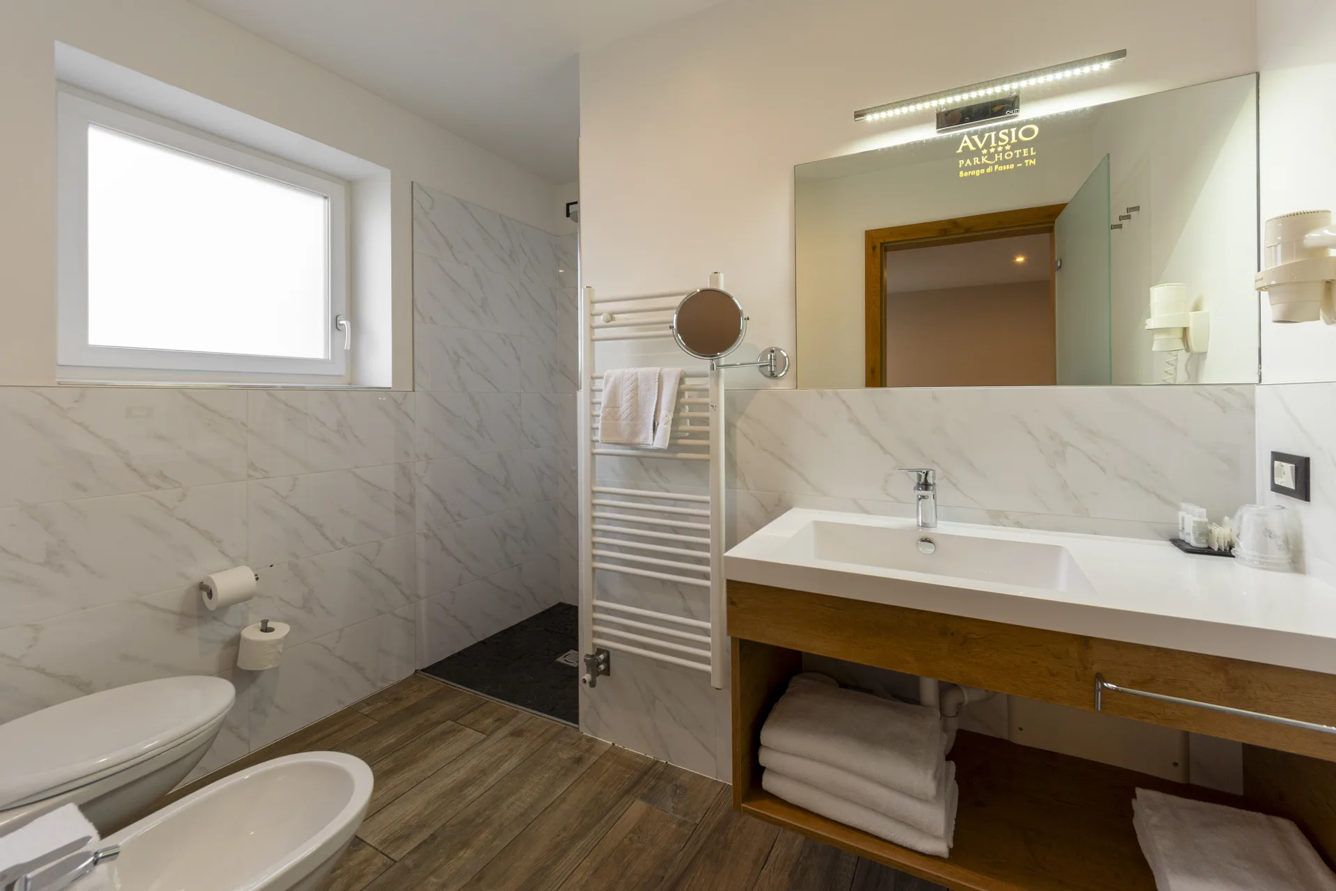 Bagno moderno con doppio lavabo, bidet, doccia e finestra luminosa