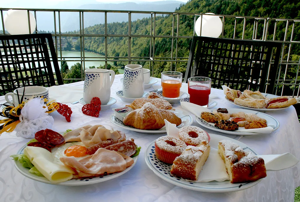 Colazione ricca servita in terrazza con vista sul lago e le montagne