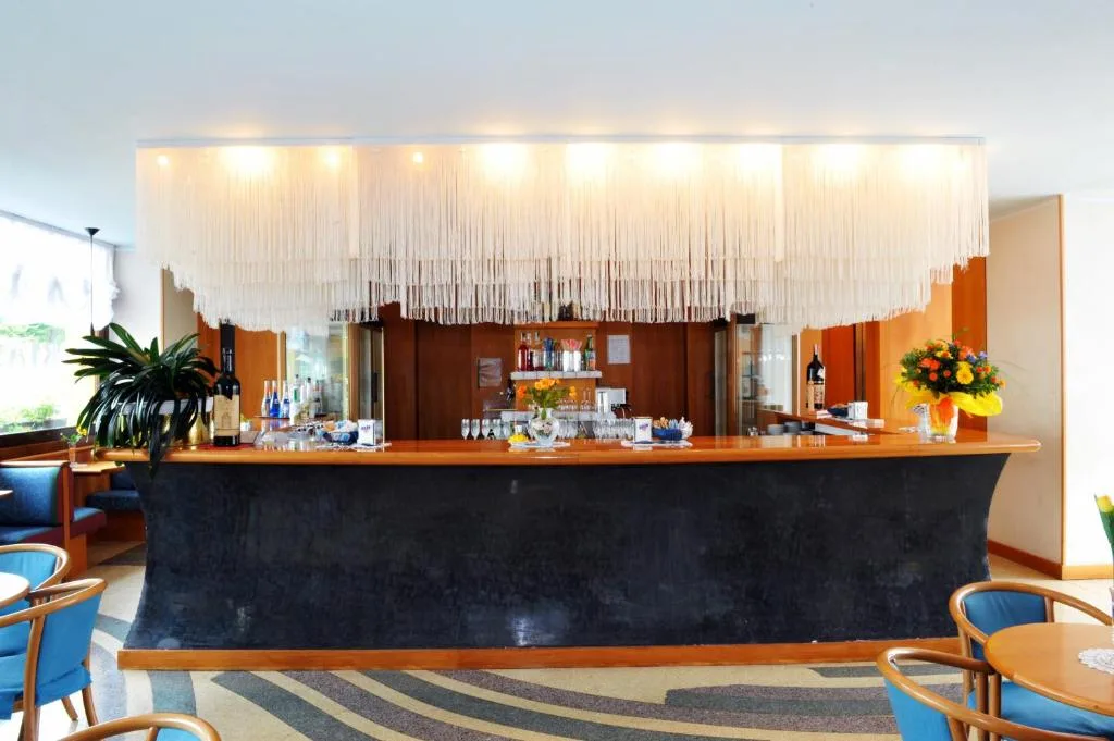 Bancone bar dell'hotel con lampadario a frange e fiori