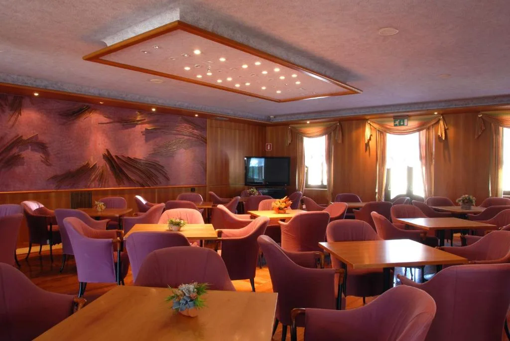 Sala soggiorno con poltrone rosa e decorazioni alle pareti