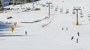 Piste da sci innevate con seggiovia e sciatori sul pendio