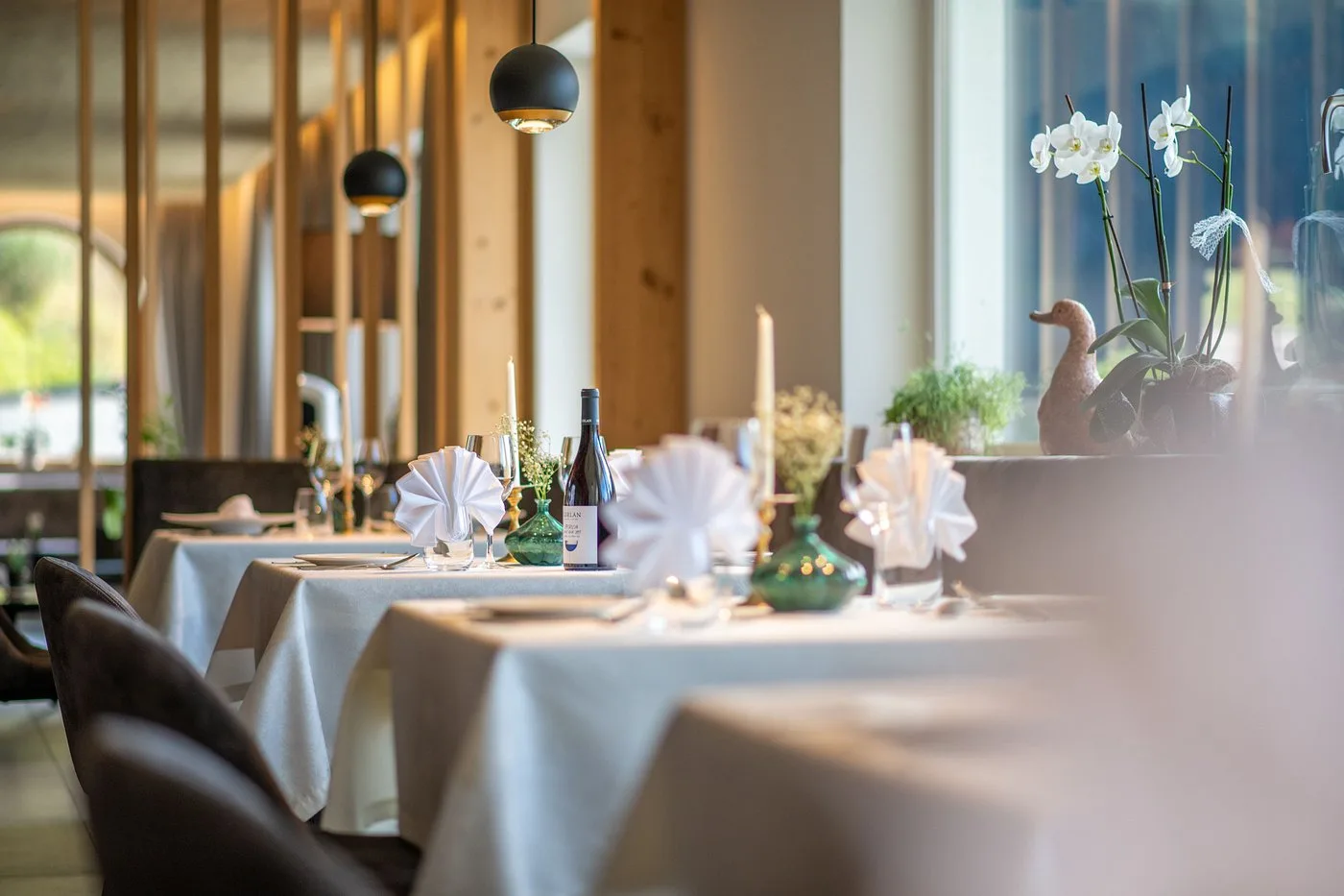 Sala ristorante elegante con tavoli apparecchiati e orchidee bianche