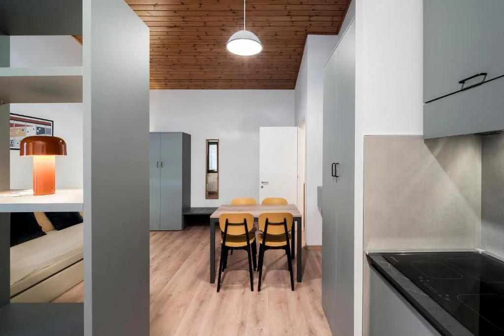 Cucina attrezzata con piano a induzione e tavolo da pranzo con sedie gialle