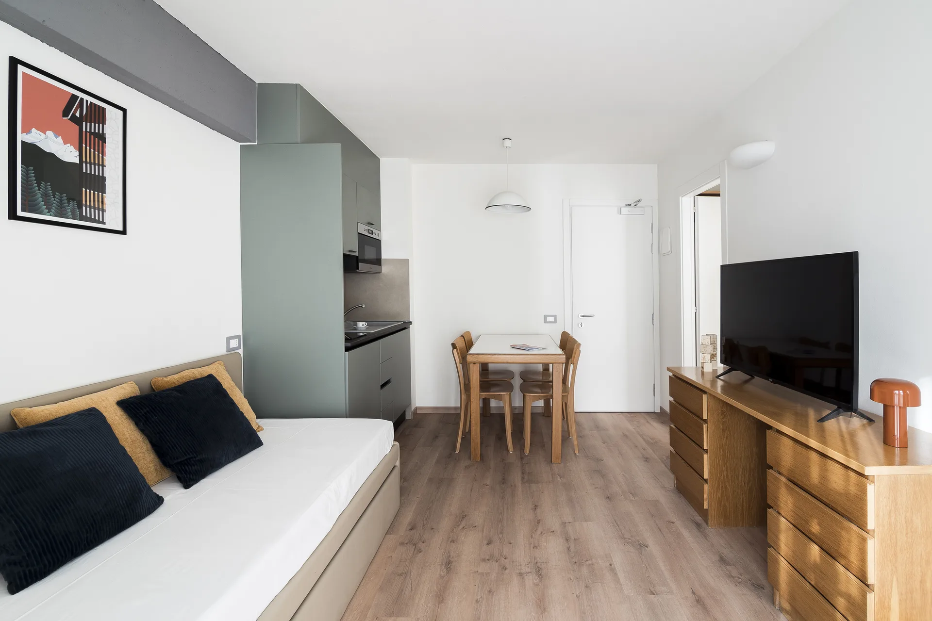 Monolocale con divano letto, angolo cottura, tavolo da pranzo e TV