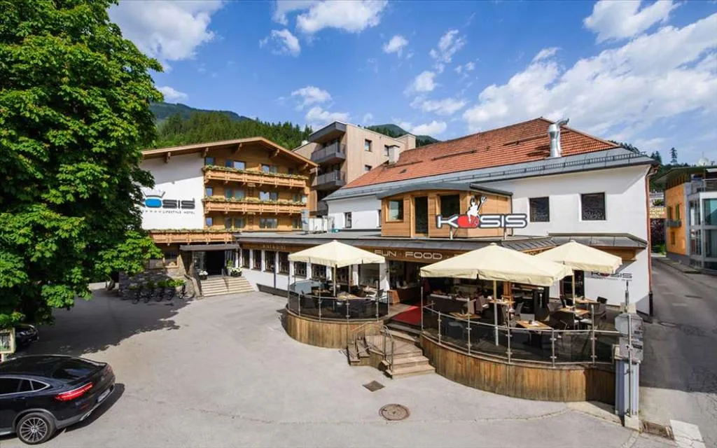 Terrazza esterna dell'hotel Kosis con ombrelloni e area ristorante in estate