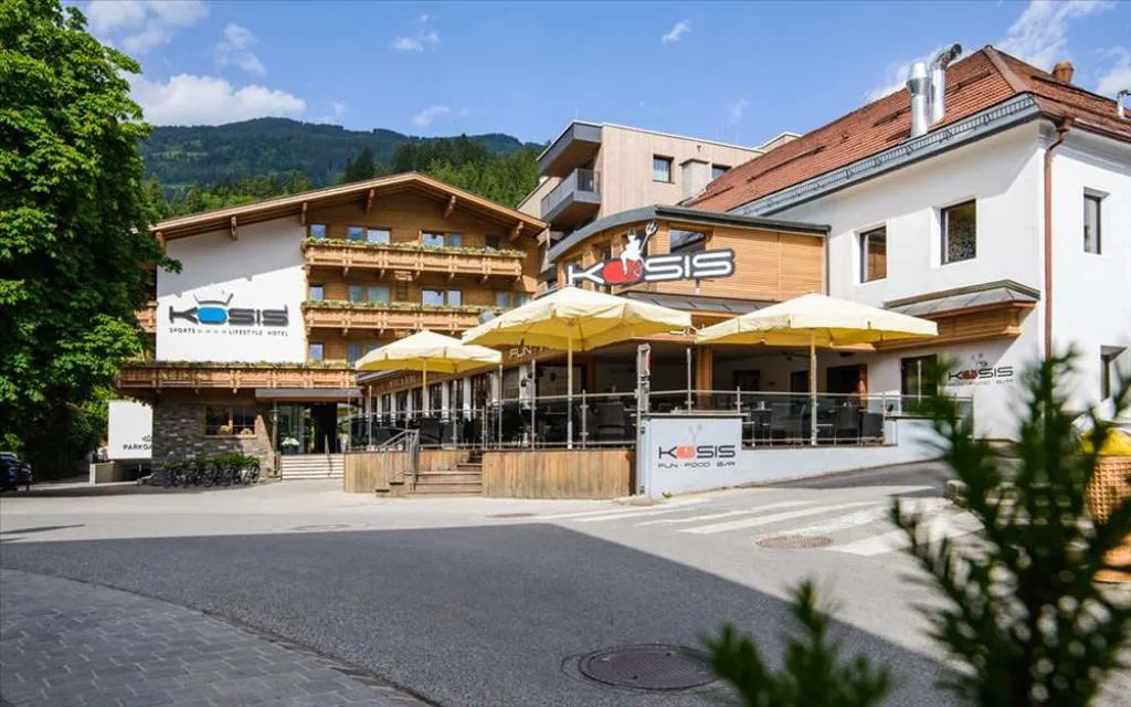 Ingresso principale dell'hotel Kosis con terrazza e ombrelloni gialli in estate